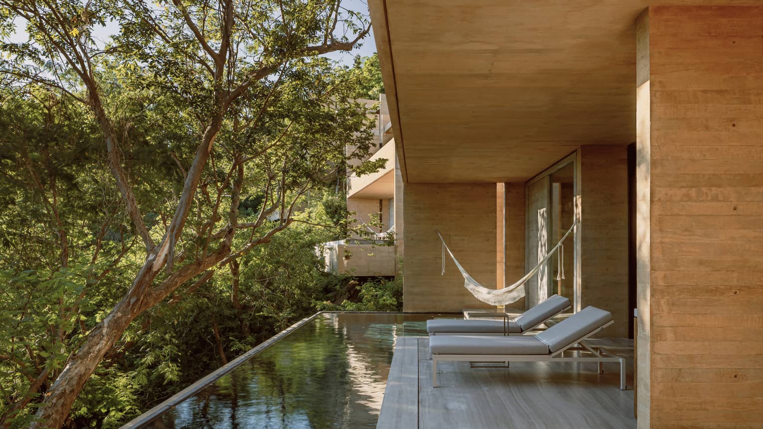 Private hotel terrace with infinity pool and two lounge chairs