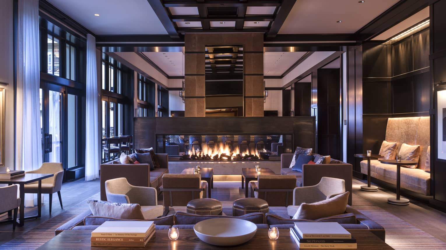 Indoor bar and lounge with a sofa, arm chairs and long fireplace
