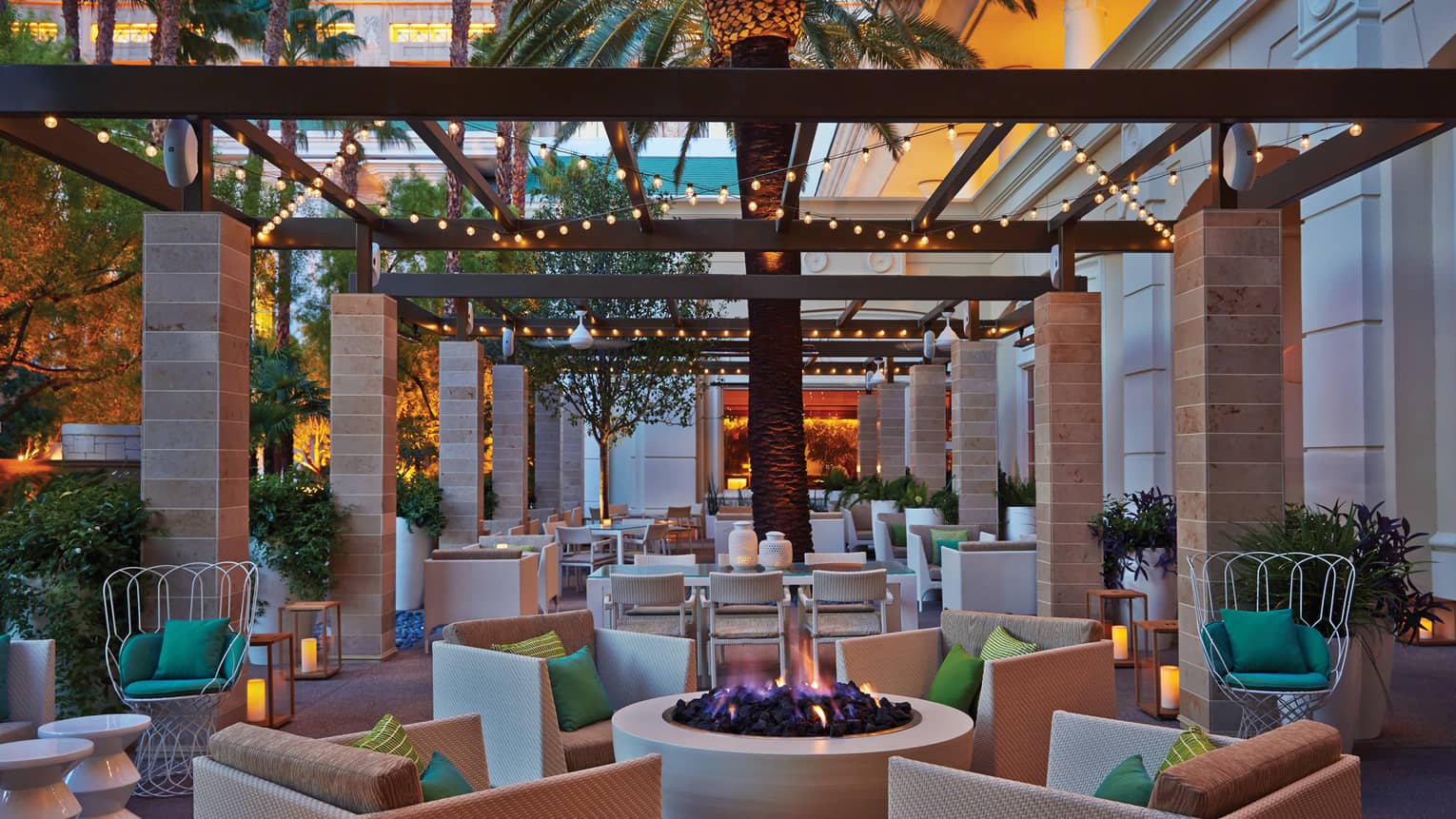 Press Lounge patio large wicker chairs around modern round outdoor fireplace