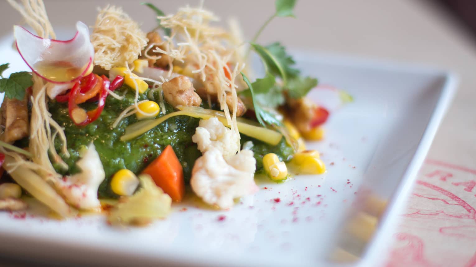 Close-up of Seasons brunch salad with cauliflower, corn, radish slices, green jelly salad