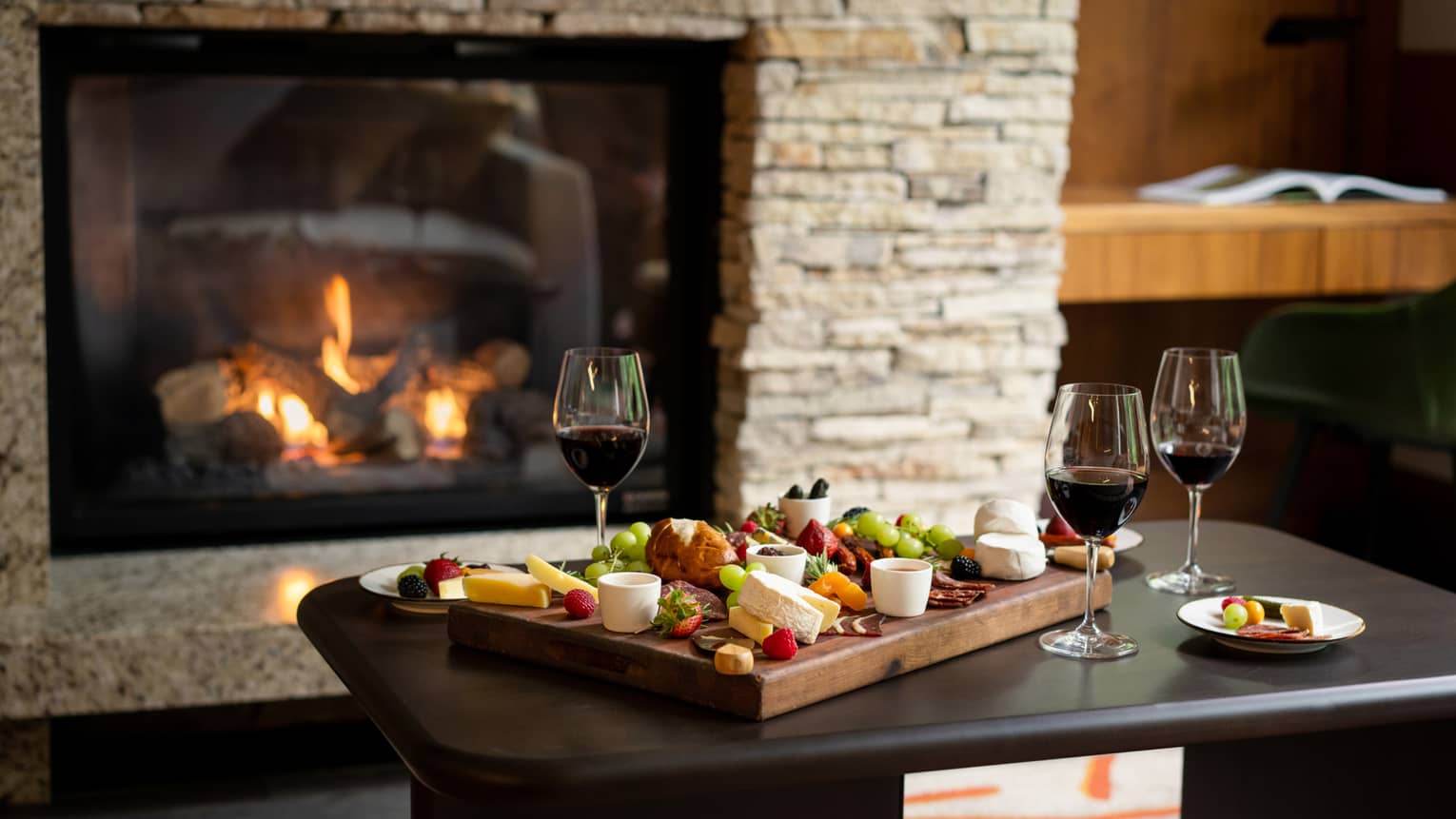 Charcuterie board, wine and living room fireplace