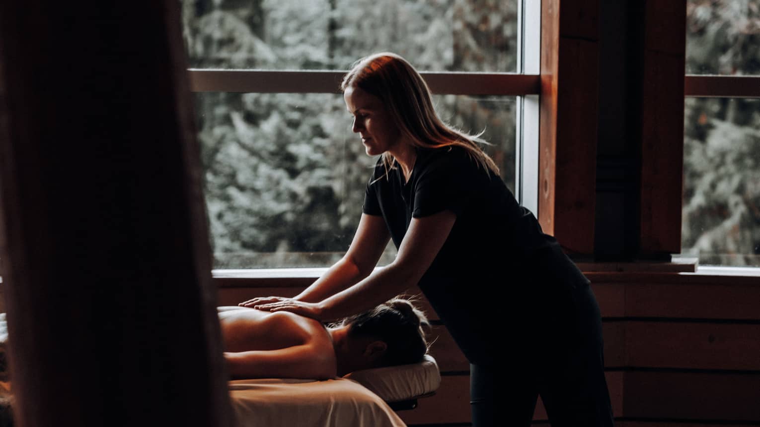 A woman receicing a massage in a dimly lit room.