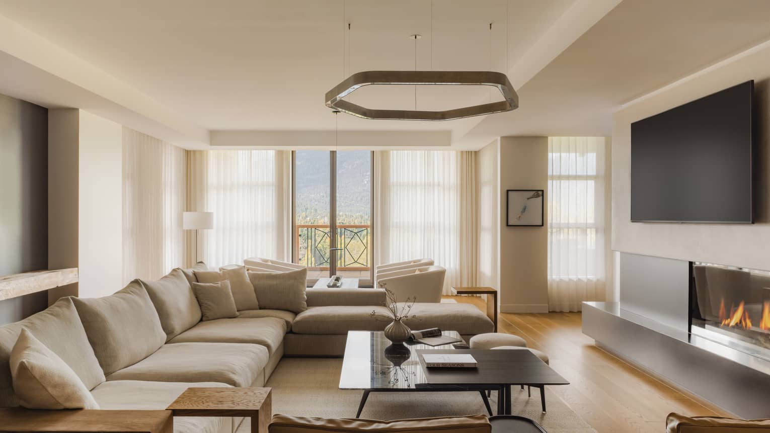 Modern living room of a mountain resort private residence, featuring large sectional sofa and fireplace