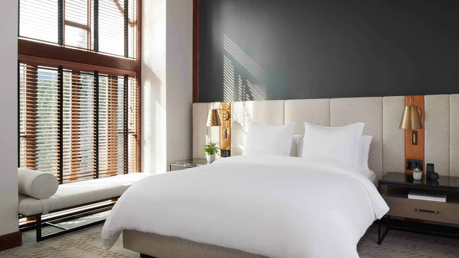 Elegant bedroom in the Executive Suite at Four Seasons Whistler, featuring a large bed with pristine white bedding. The room includes a stylish bedframe and headboard, bedside tables with modern lamps, and a bench at the foot of the bed. Large windows with wooden blinds allow for ample natural light, creating a warm and inviting atmosphere. The decor is complemented by soft neutral tones and contemporary design elements.,Elegant bedroom in the Executive Suite at Four Seasons Whistler, featuring a large bed with pristine white bedding. The room includes a stylish bedframe and headboard, bedside tables with modern lamps, and a bench at the foot of the bed. Large windows with wooden blinds allow for ample natural light, creating a warm and inviting atmosphere. The decor is complemented by soft neutral tones and contemporary design elements.