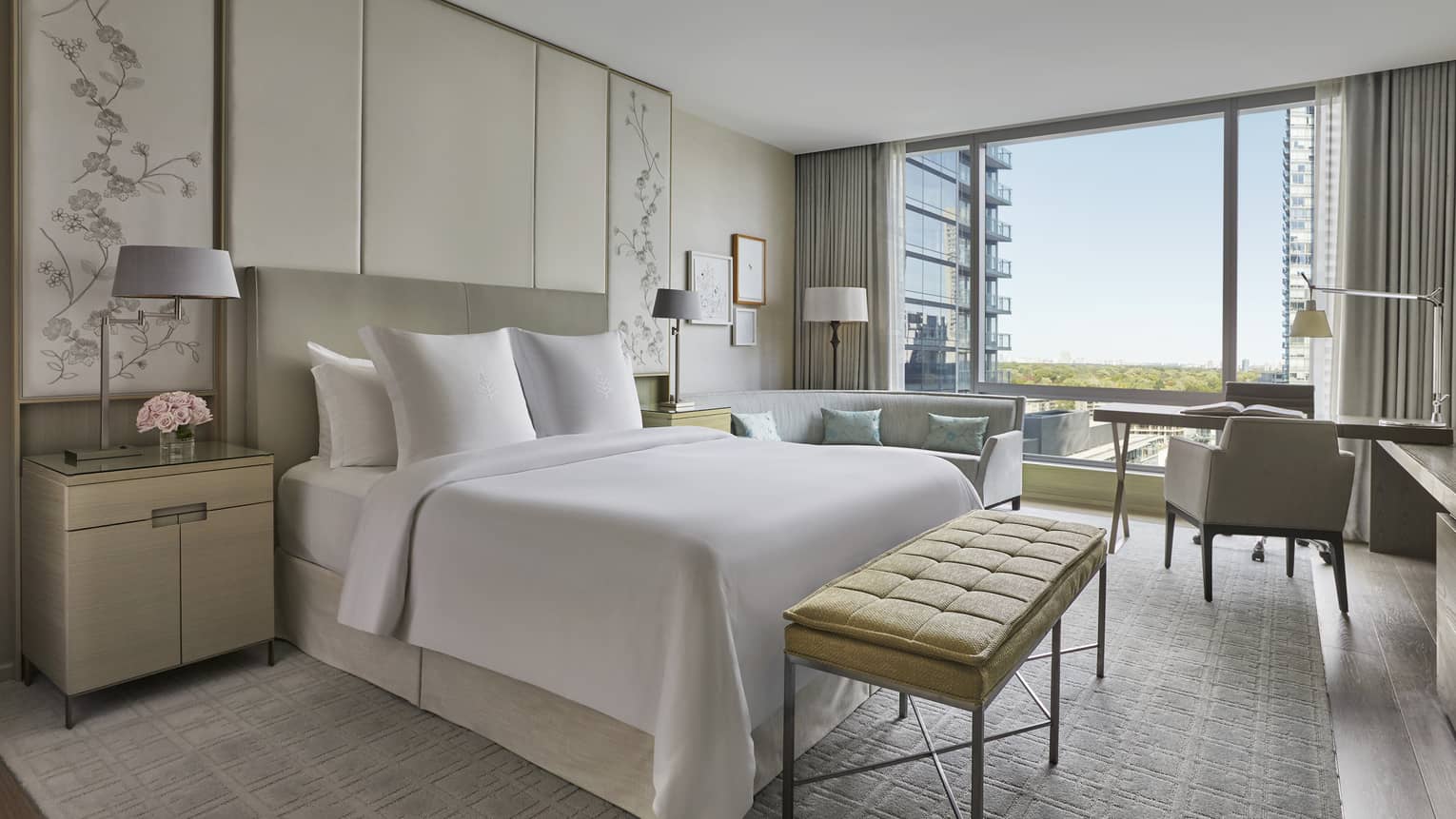Hotel room with cream, white and light grey colouring, king bed, floor-to-ceiling windows