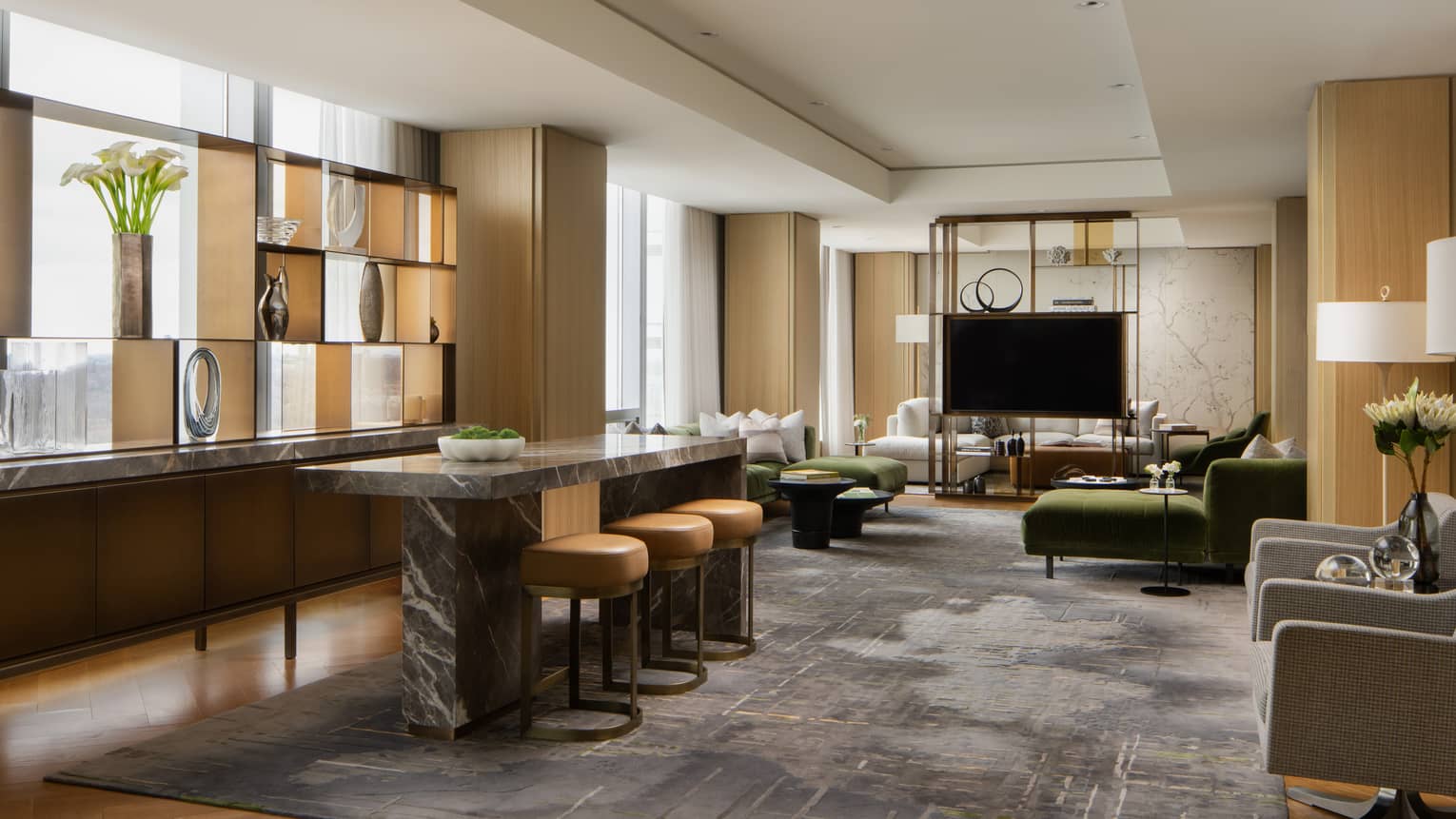Royal suite living area with an open layout featuring a marble-top counter, a large TV, elegant décor and comfortable seating