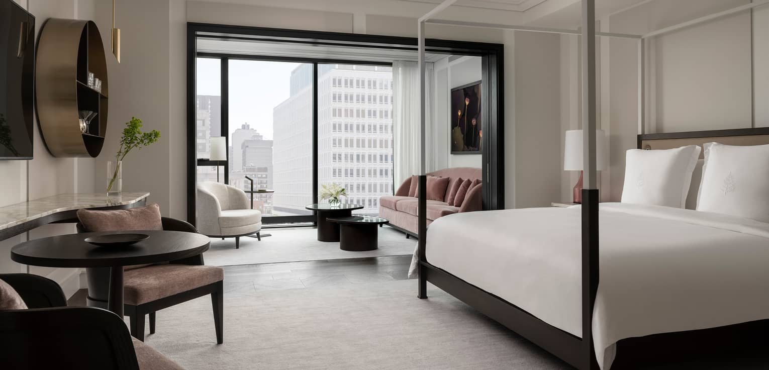 Chic, modern guest room with neutral decor and black trim, floor-to-ceiling window