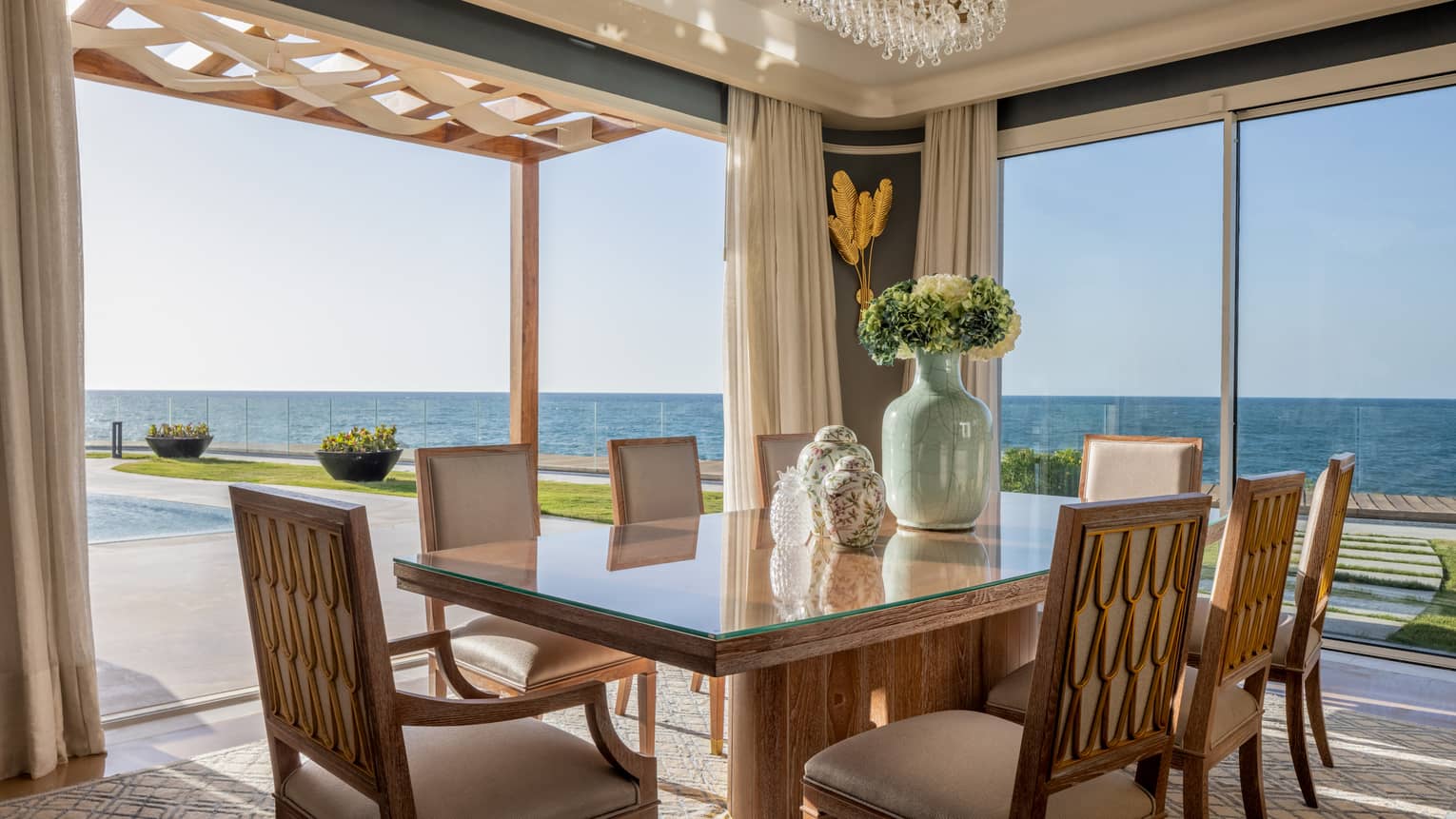 Open air dining area with sliding glass door to partially covered portico, ocean views