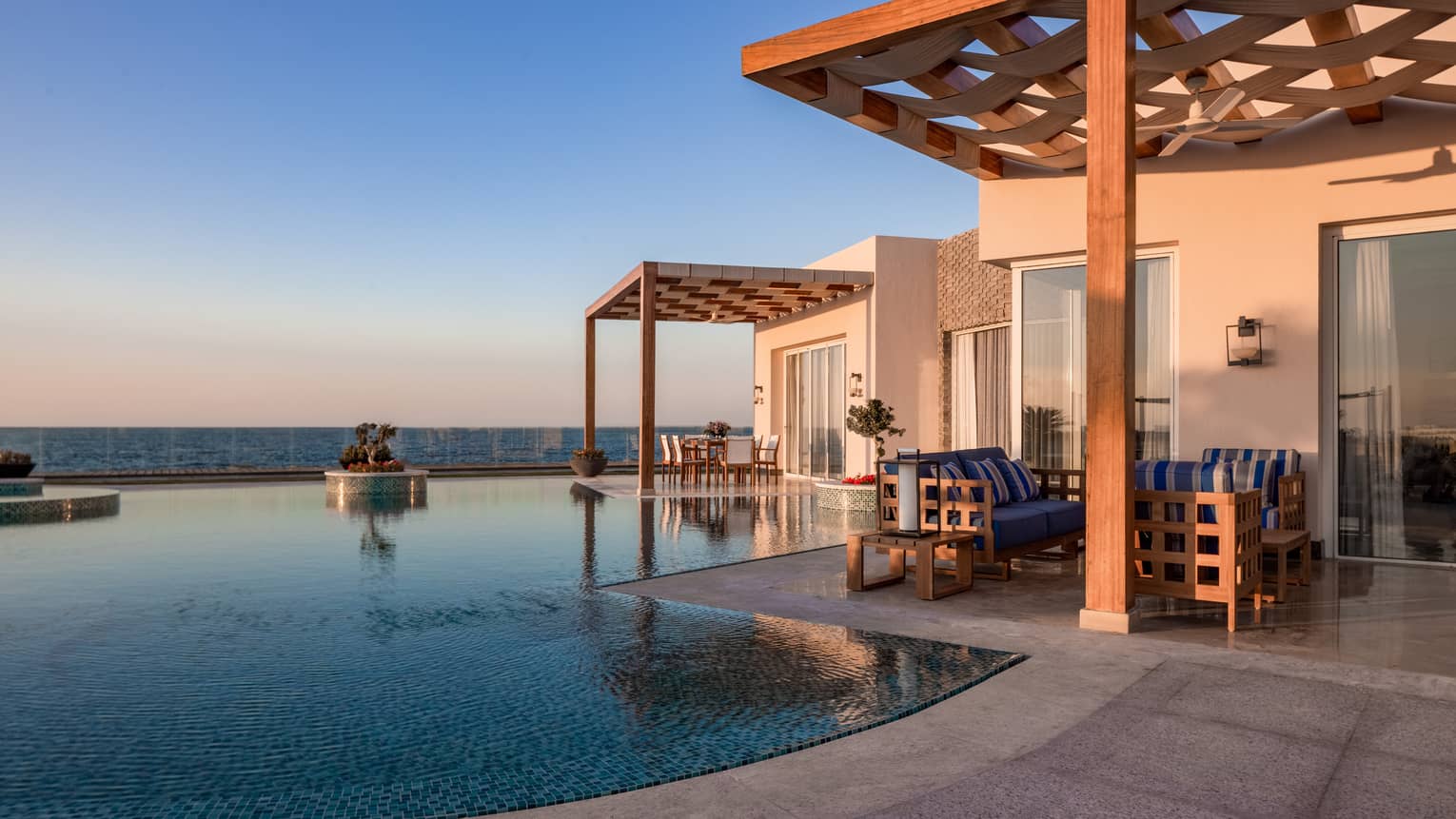 Pool and covered patio of The Palace at sunset