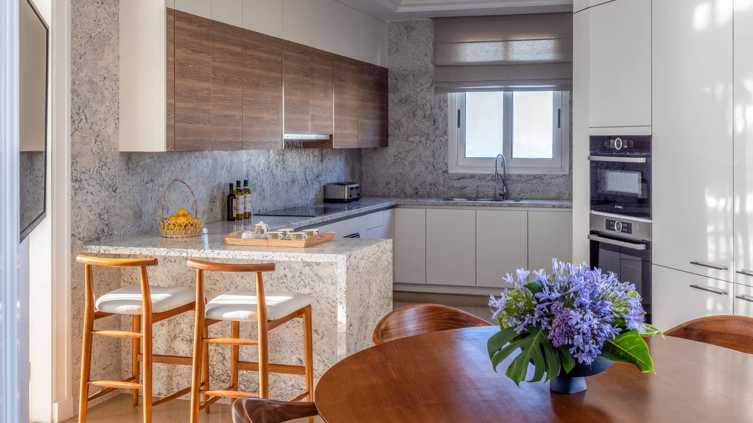 The Palace kitchen with marble countertops, round dining table, bar stools