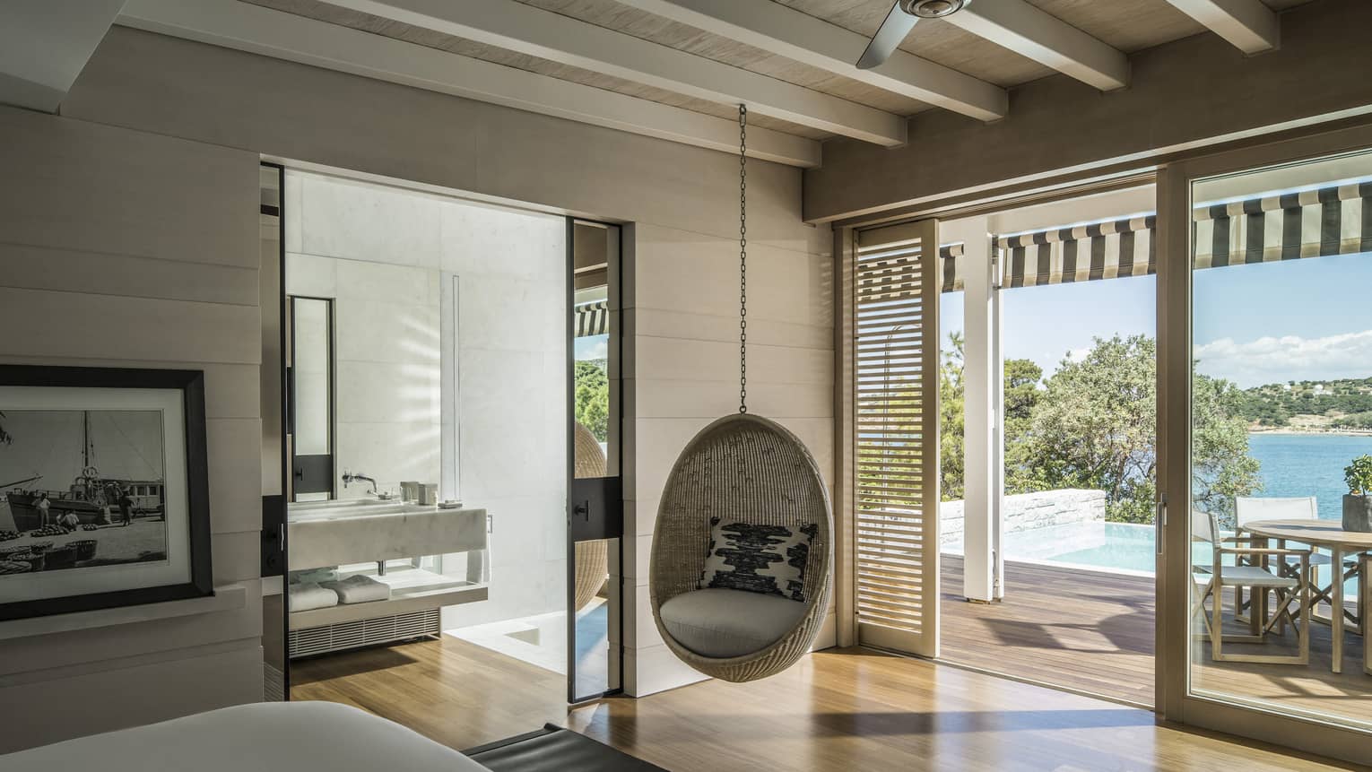 Bungalow Suite with Pool Bedroom with hanging rattan egg chair, mirrored doors to bathroom, sliding glass doors leading to terrace, ocean views