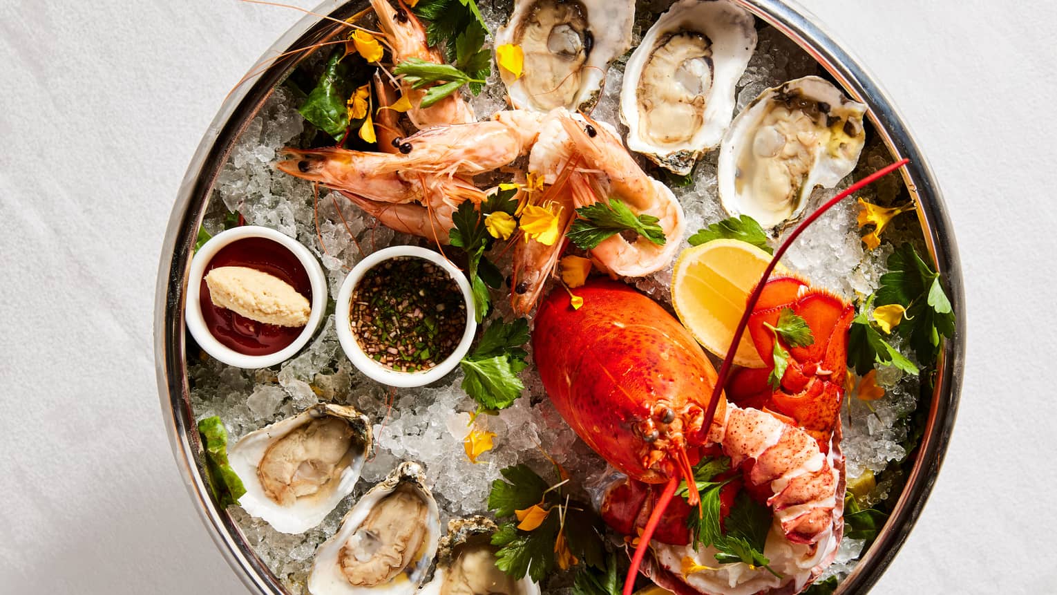 Oysters and a lobster in a bowl of ice.