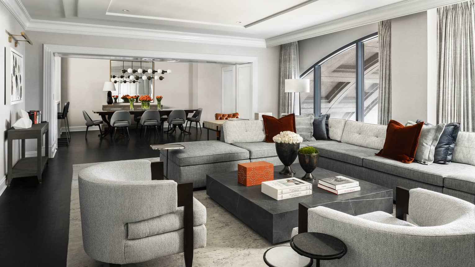 Presidential Suite large seating area with modern grey furniture, dining table