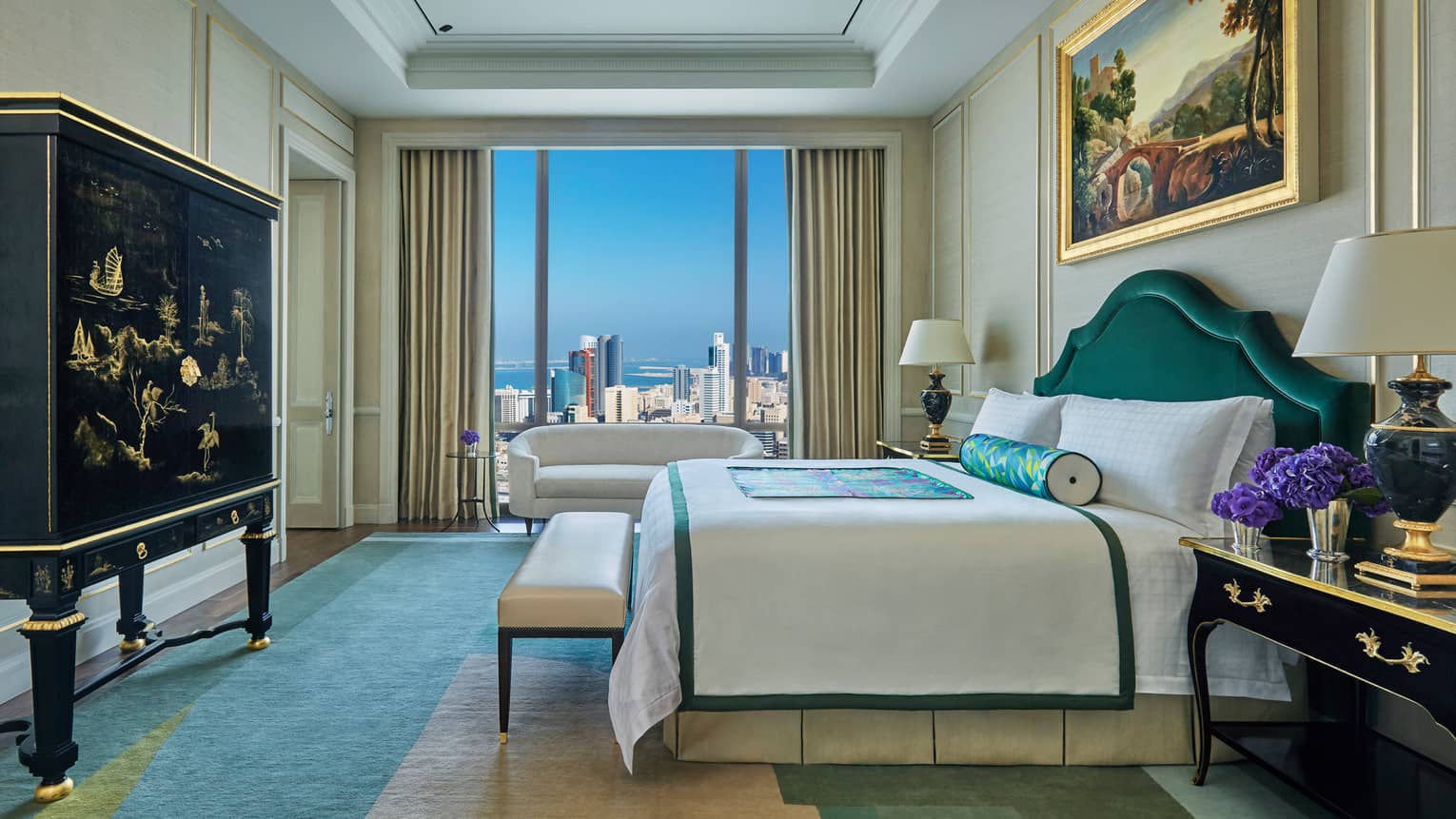 Presidential Suite side view of bed, bench at foot, decorative black dresser, window with city view