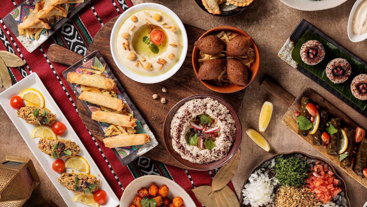 A large spread of mezzeh on long rectangular plates.