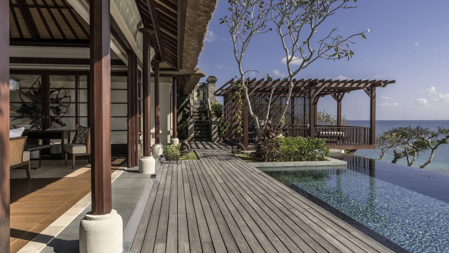 Royal villa wood patio boards, wood pillars, infinity pool looking out at ocean