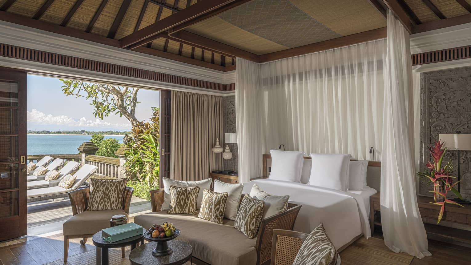 Royal Villa bedroom with canopy bed, doorway to pool and lounge area