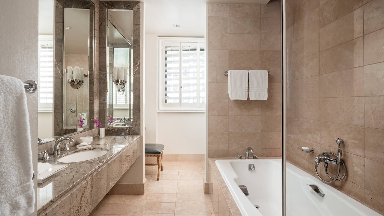 Bathroom with tub and marble vanity with one sink