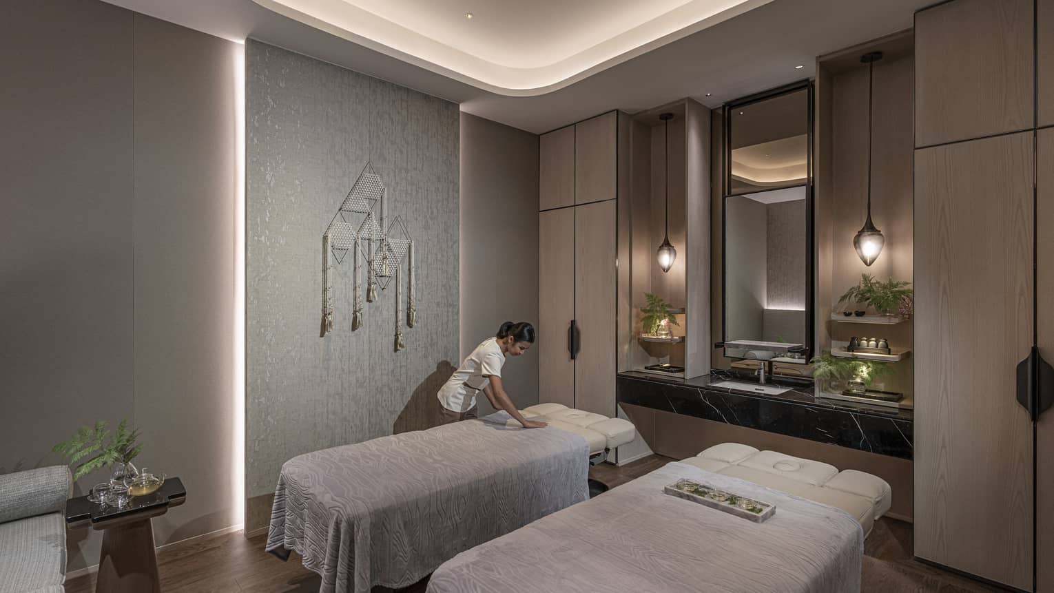 Massage therapist prepares a couples treatment room