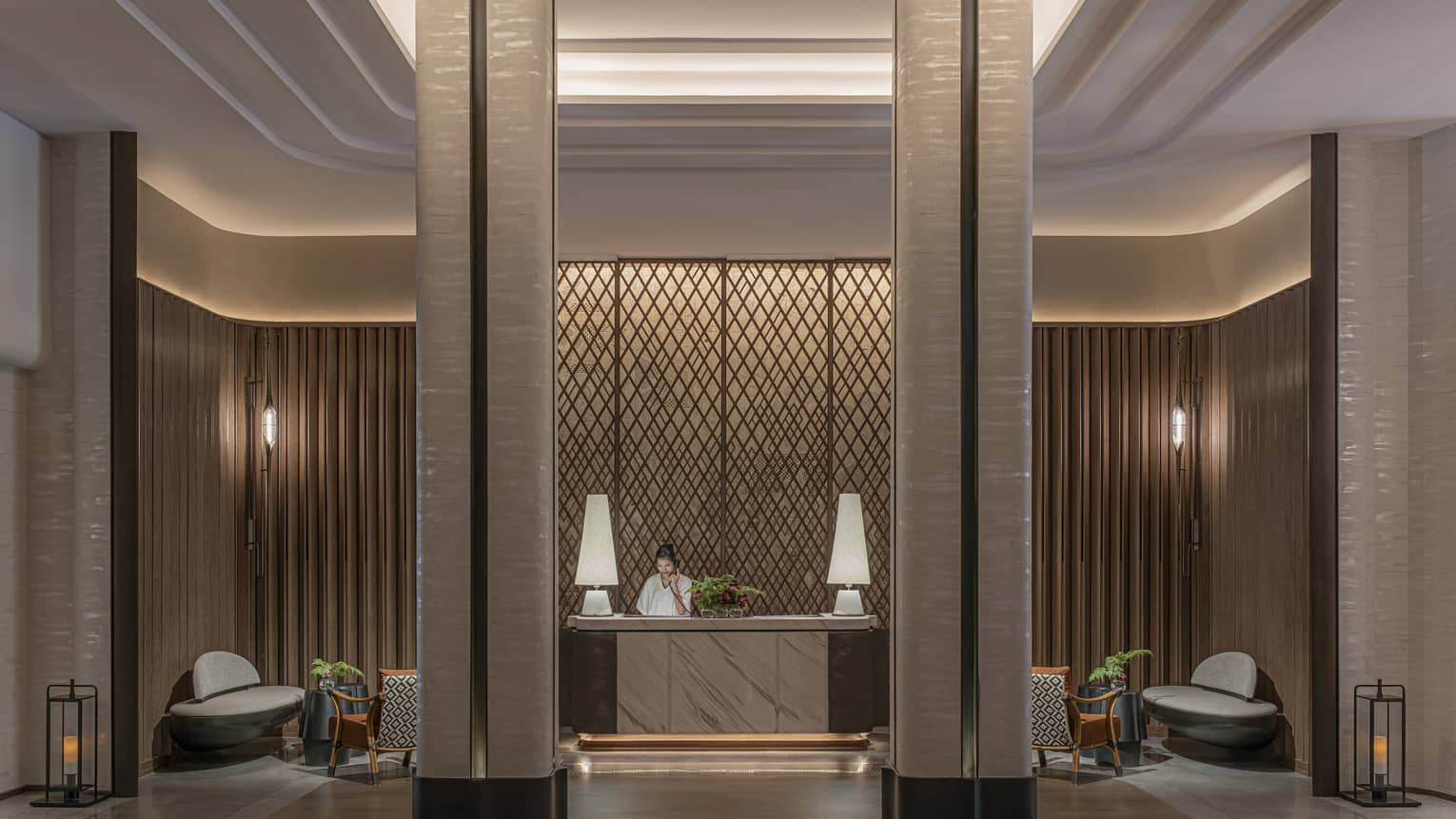 Spa lobby with floor-to-ceiling columns, lighted wall sconces and reception desk