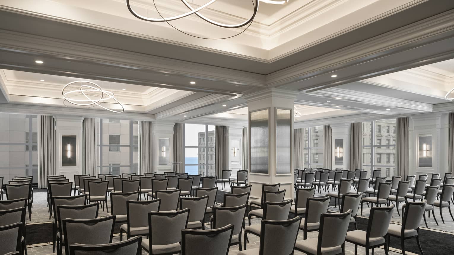A small ballroom with many chairs placed in rows. 
