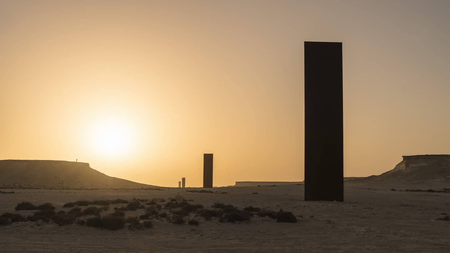 Silhouettes of Richard Serra Sculpture against sunset