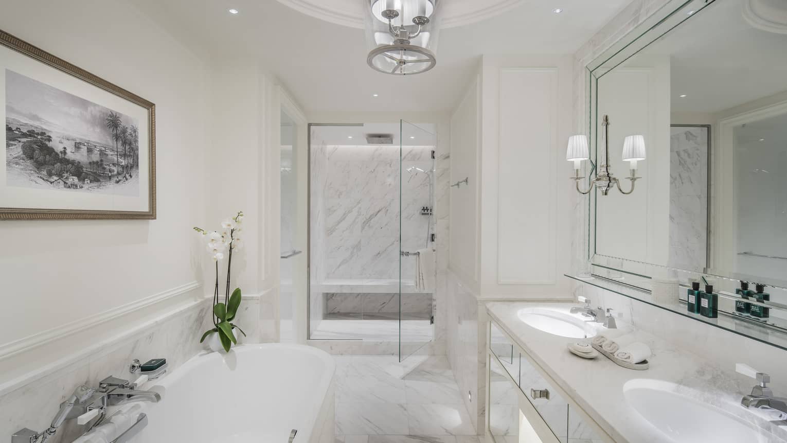 A marble bathroom with a large tub separate from a glass-walled shower.
