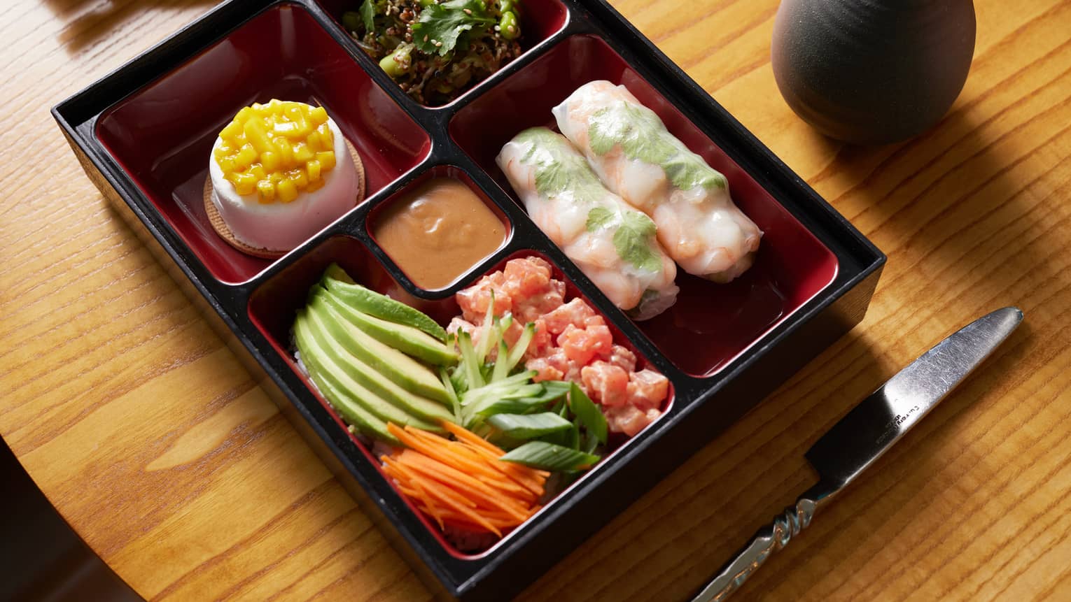 Bento box with assorted sashimi, crudo and julienne vegetables