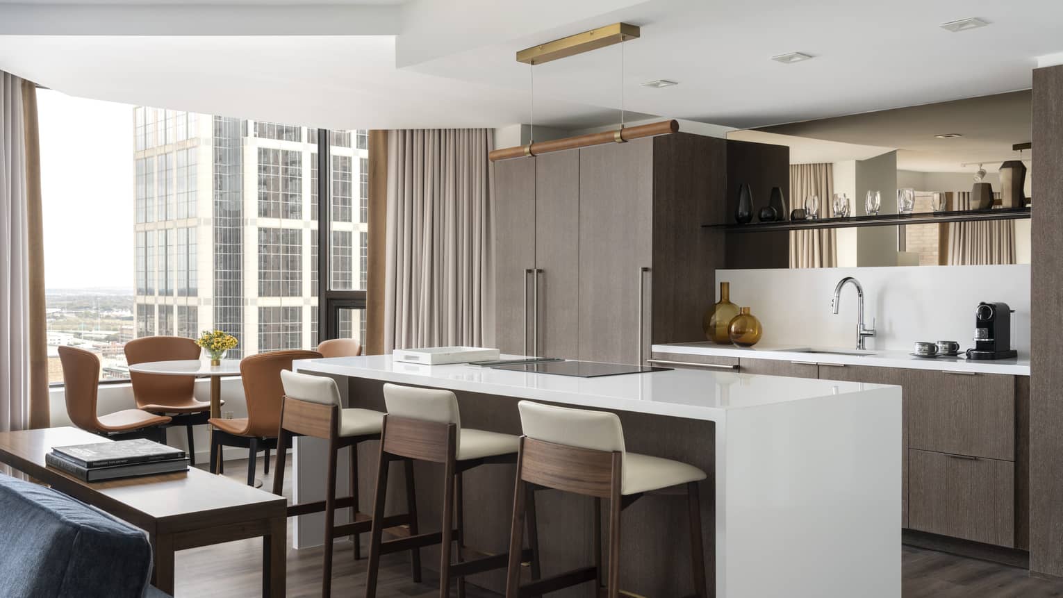 A kitchen area with large island near large windows in a hotel suite.