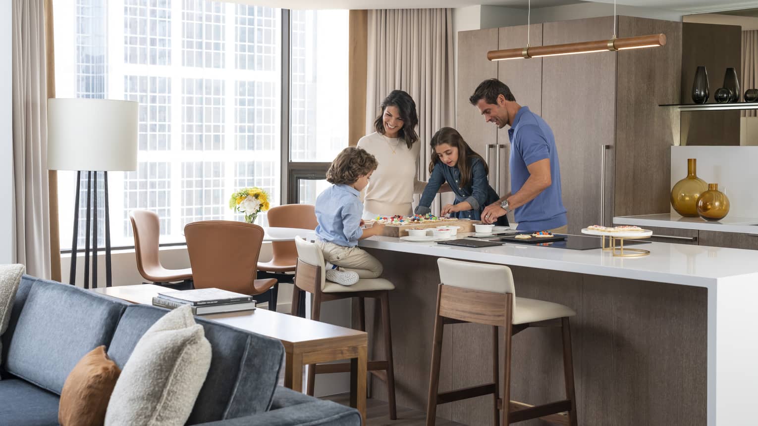 Woman, man, young girl and young boy eat at a kitchen island
