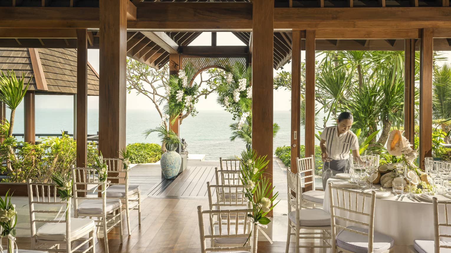 Wedding specialist sets banquet table at open-air wedding venue