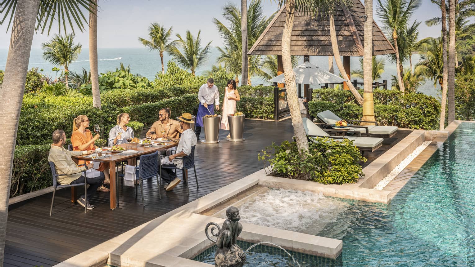 Group of friends enjoys a poolside barbecue lunch