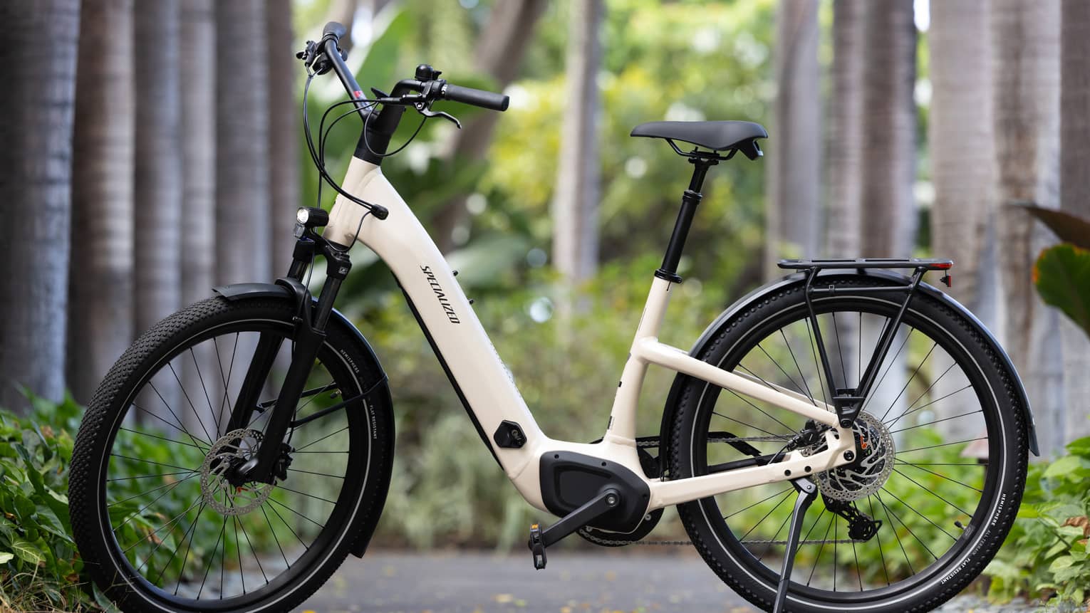 A stationary e-bike on a sidewalk with trees in the background.