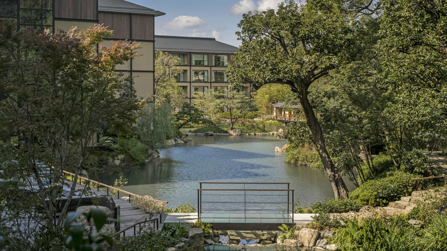 Trees, Shakusuien garden around pond under Four Seasons Hotel Kyoto building