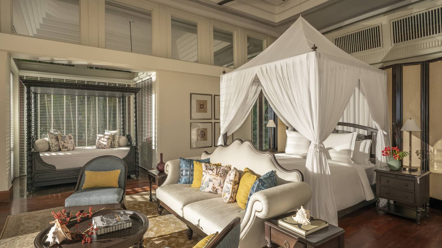 Opulent bedroom with canopy king bed, sofa and two arm chairs