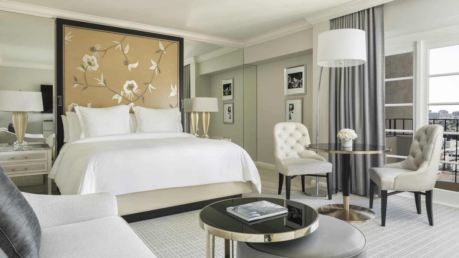 Studio Suite cafe table, bed by padded floral headboard