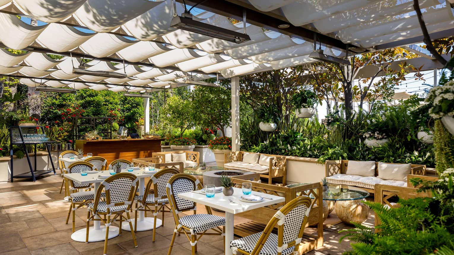 An outdoor covered eating area surrounded by plants.