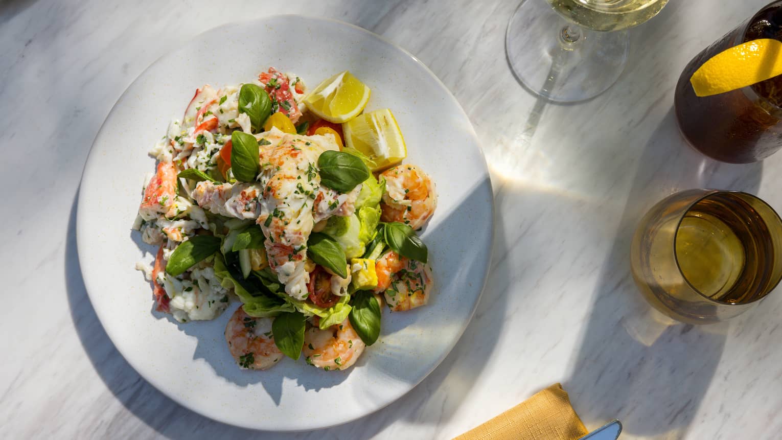 Shrimp with greens, lemon, and a glass of wine.