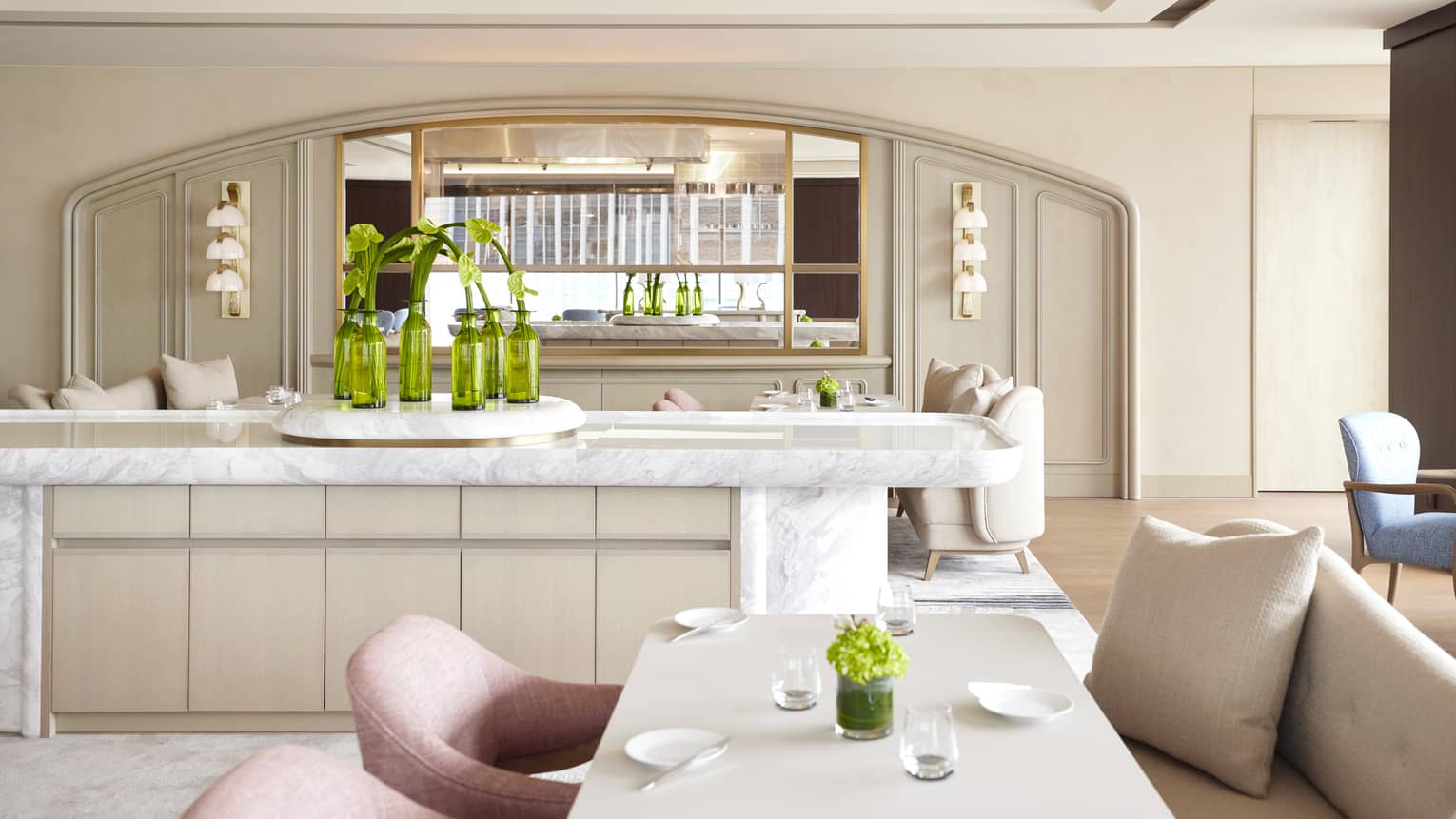 Sezanne dining room with soft beige and desert rose colours, natural light, large marble island, greenery throughout
