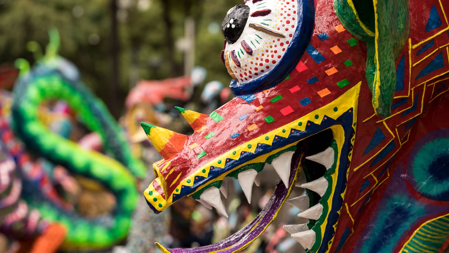 Close-up of colourful lizard mask eye, horn, teeth and tongue, part of a celebration 