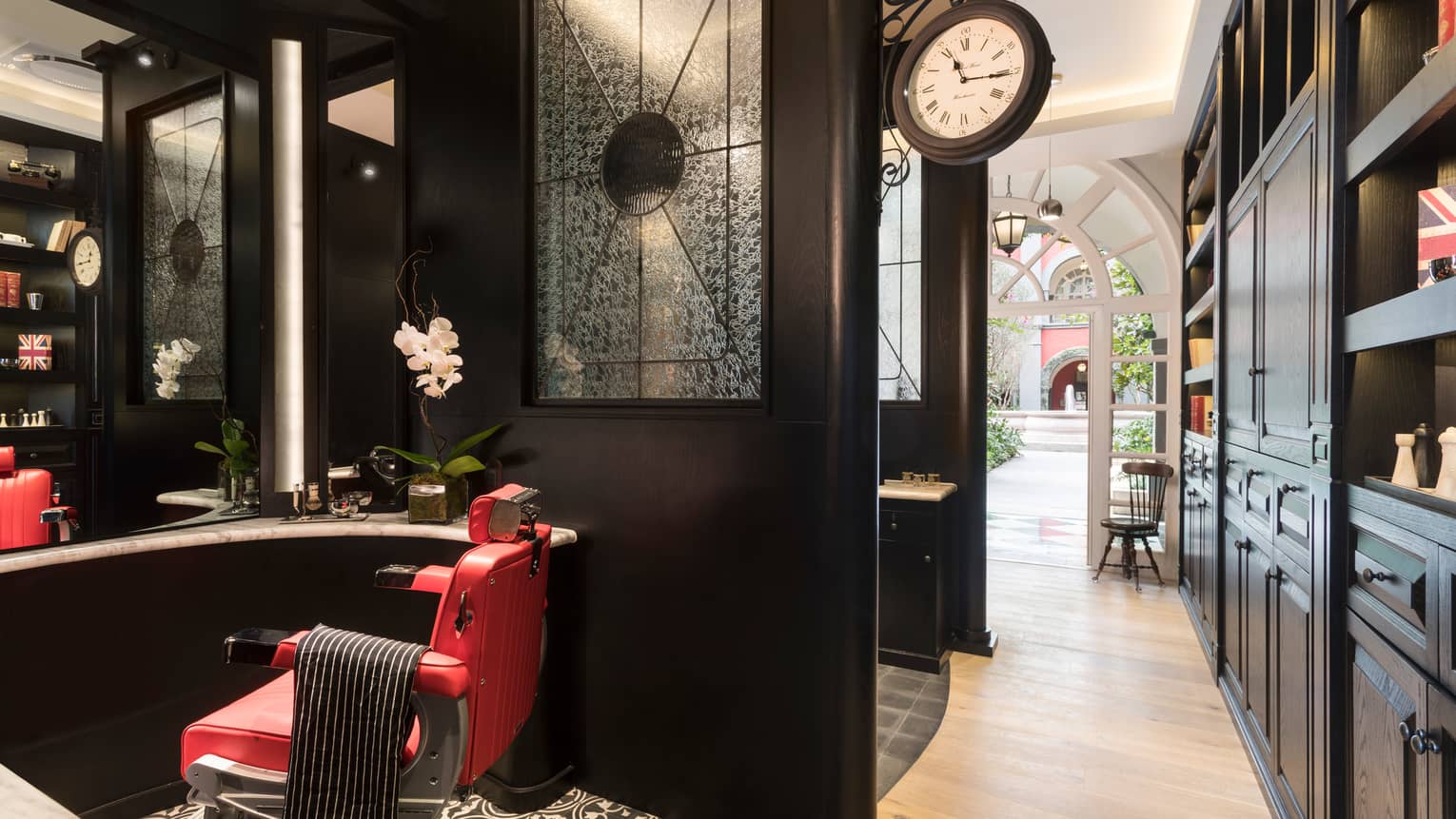 Gentlemen's Tonic barbershop red barber chair, orchid by mirror over black wood vanity