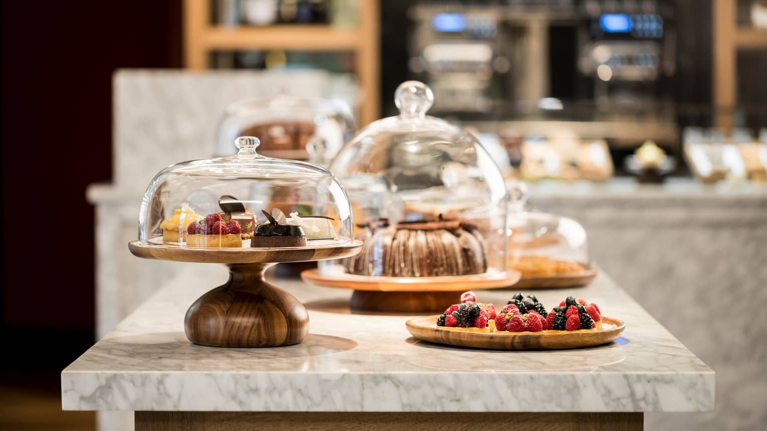 Sweets, desserts and pastries in glass cake displays on Pan Dulce white marble counter