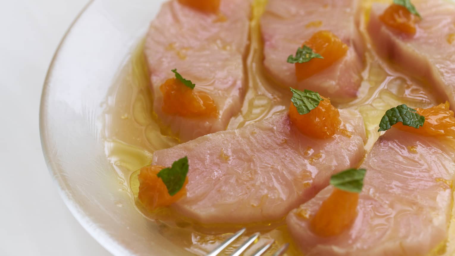 A seafood dish topped with leafy greens