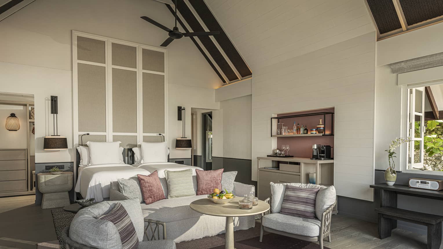 Bedroom with vaulted beamed ceiling, king bed, sofa and two chairs