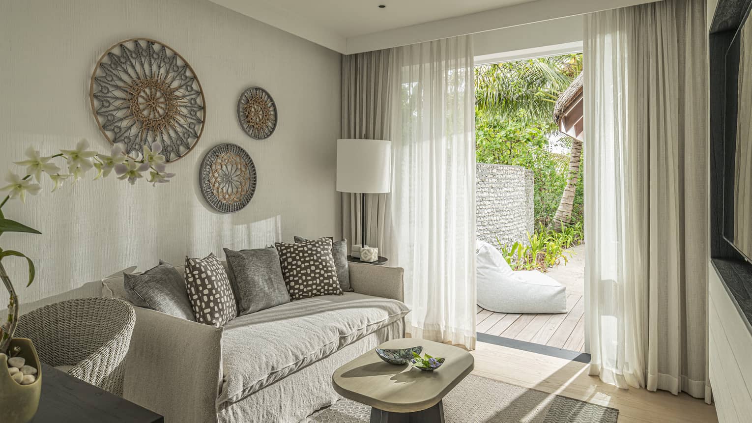 Bedroom with sofa, desk and walk-out deck with lounge chair