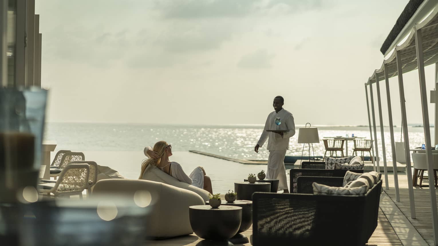 A guest receives a cocktail while relaxing outside at the Blu Beach Club