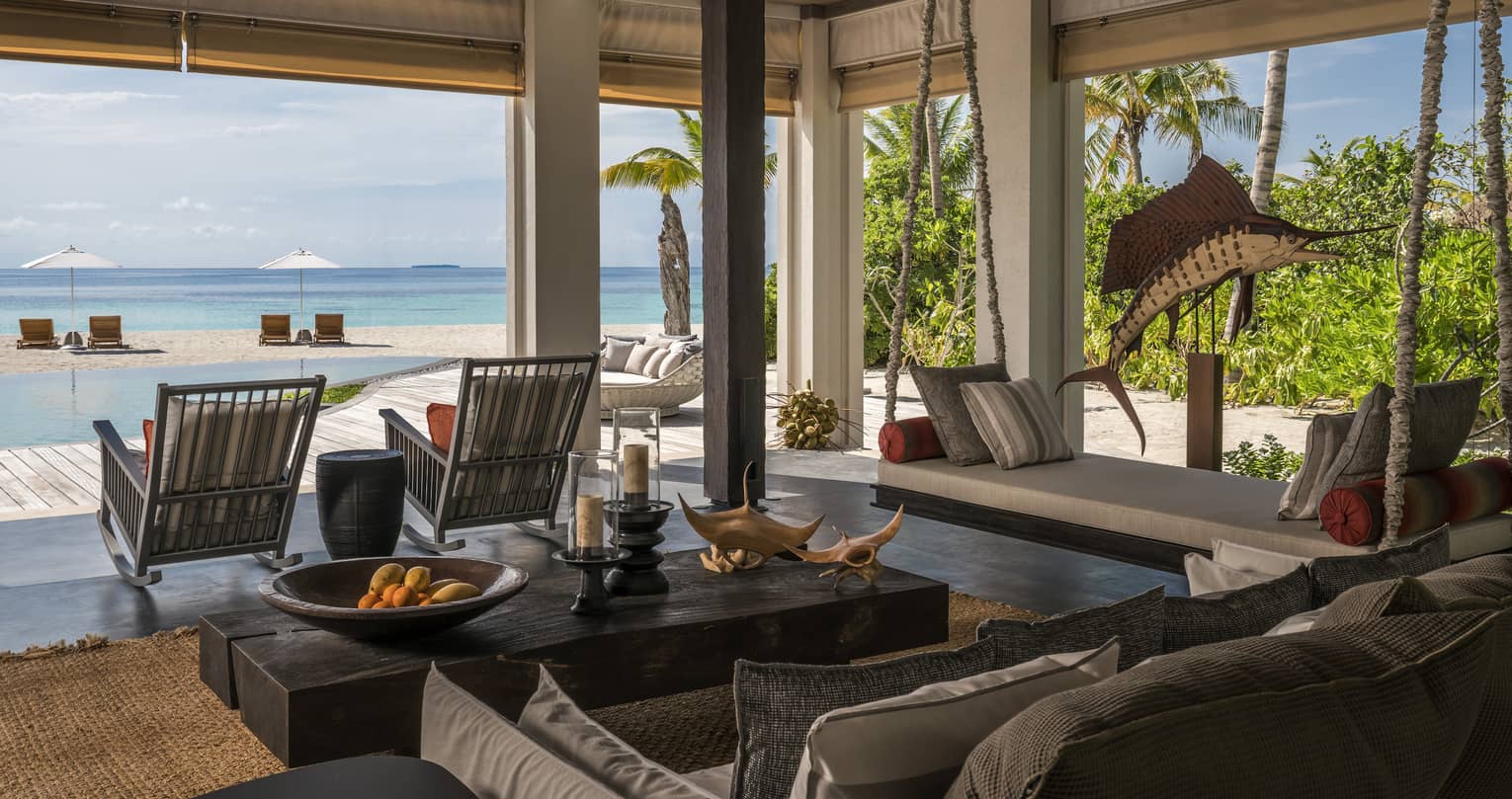 The Beach House open-air living room, sofa, table with oranges and wood manta ray carvings