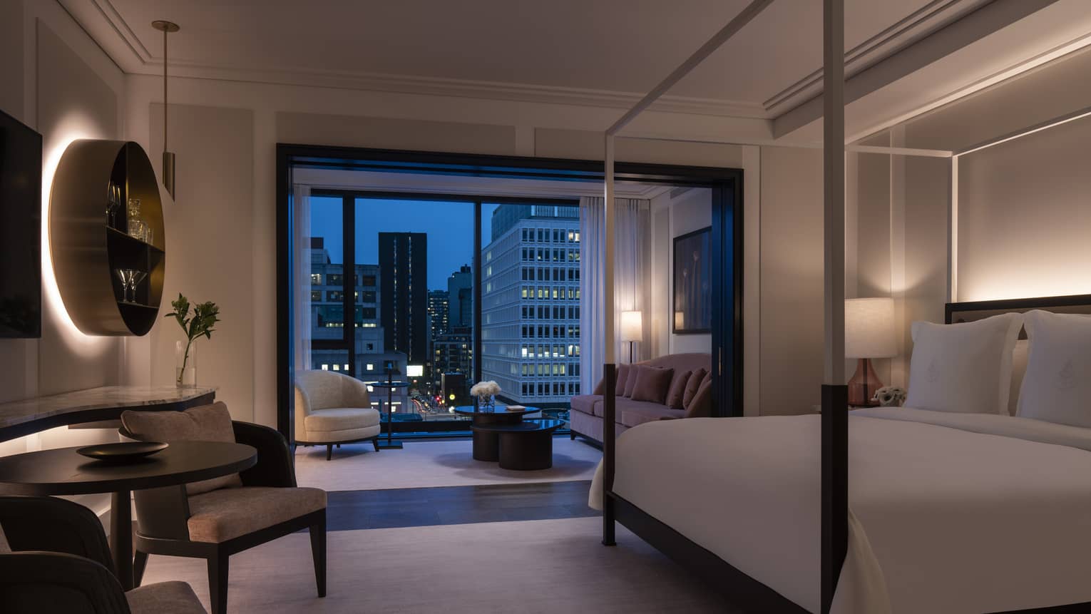 Four Seasons Executive Suite, dimly lit with four-poster modern bed and evening patio views