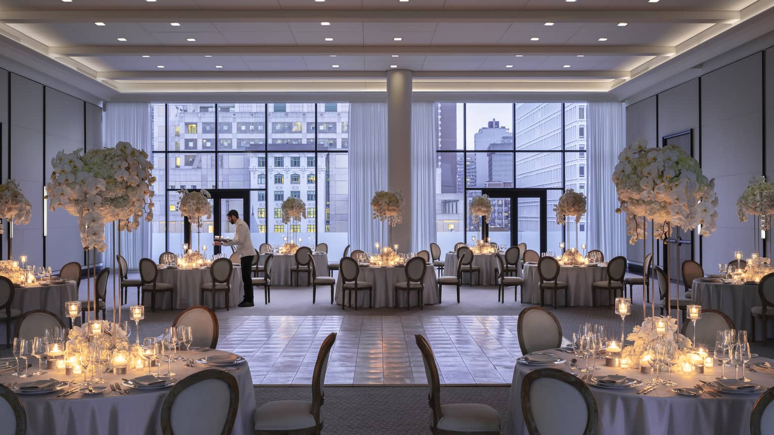 Four Seasons staff sets round table with candles in Palais des Possibles Ballroom