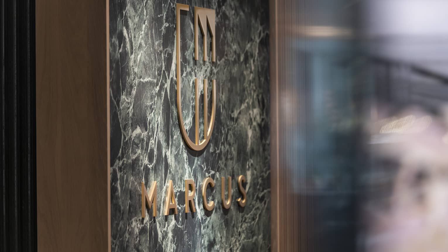 MARCUS Restaurant sign with gold letters on marble wall panel